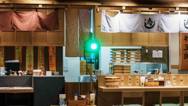 食のHANAMICHI 内藤新宿 暖簾とグリーンのピンスポットを配した店内カウンター